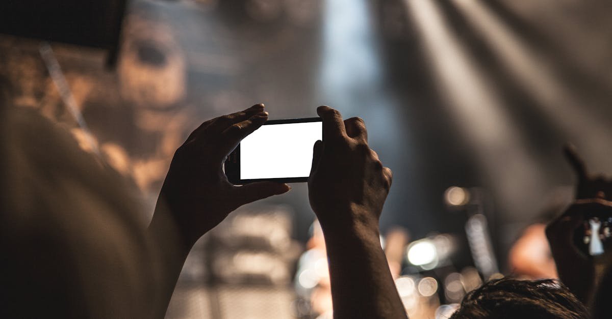 A vibrant concert scene featuring a smartphone capturing the live music experience.